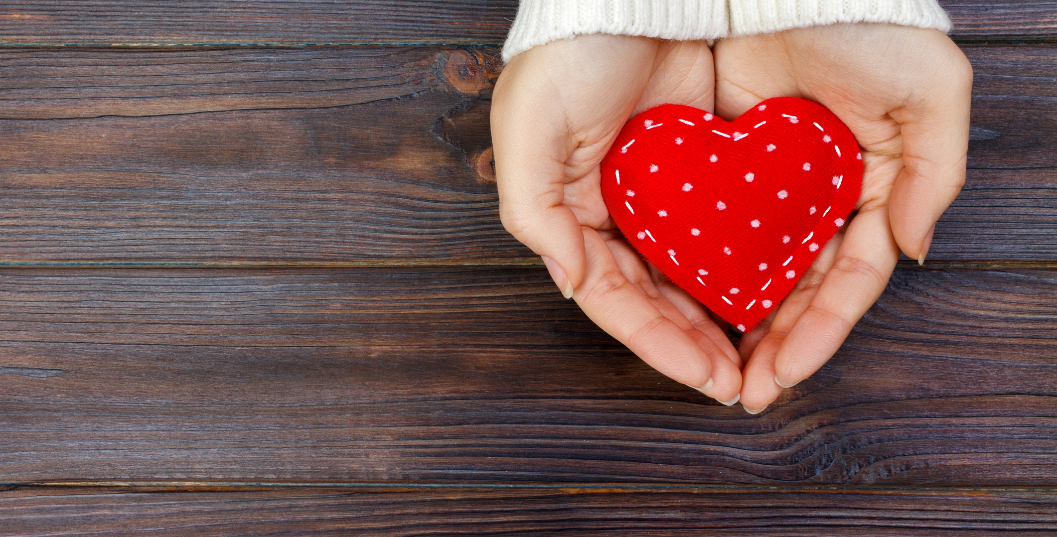 Hands holding a heart pillow